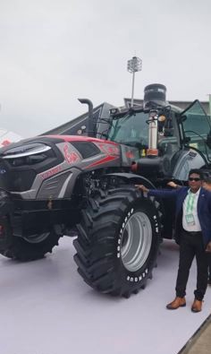 KCCIMA delegate beside a large grey and red tractor